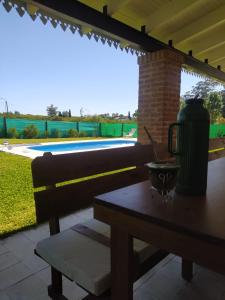 a table with a thermos on a patio with a view of a yard at Casa quinta La Justina in Concepción del Uruguay