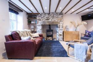 a living room with a couch and a stone fireplace at Gorgeous Cottage Near the Sea. Dog Friendly. in Ederyn
