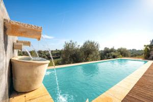 una piscina con una fuente de agua en Trullo with Pool, en Ceglie Messapica