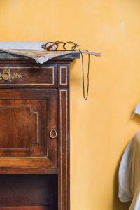 un par de gafas sentadas en la parte superior de un armario de madera en Casa D'aria, en Catania