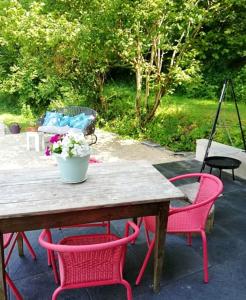 uma mesa de madeira com cadeiras vermelhas e um vaso de flores em Maison de 2 chambres avec jardin amenage et wifi a Poitiers em Poitiers