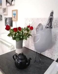 uma mesa com um vaso de rosas e um bule de chá em Maison de 2 chambres avec jardin amenage et wifi a Poitiers em Poitiers