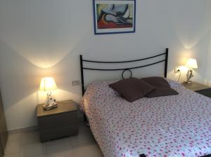 a bedroom with a bed with two night stands and two lamps at Creúsa de ma Calasetta in Calasetta