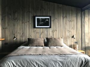 a bedroom with a bed with a wooden wall at Hotel & Cava Estancia Rilán in Castro