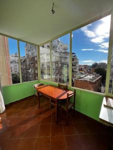 a table and chairs in a room with large windows at SunShine APARTMENT in Tirana