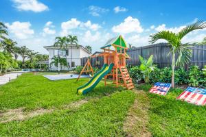 un parque infantil con un tobogán en un patio en Miami Oasis with Lakefront Beach Jacuzzi and Golf L56 en Tamiami