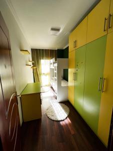 a room with green and yellow cabinets and a bedroom at SunShine APARTMENT in Tirana