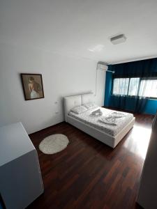 a bedroom with a bed and a wooden floor at SunShine APARTMENT in Tirana