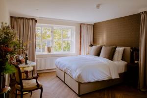- une chambre avec un grand lit et une fenêtre dans l'établissement Boetiekhotel De Kastanjehof, à Lage Vuursche
