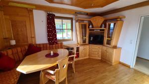 uma sala de estar com uma mesa de madeira e uma cozinha em Appartement Schwindelfrei em Niederndorferberg