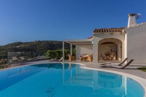 a swimming pool in front of a house at Villa Oltremare - Homelike Villas in San Teodoro