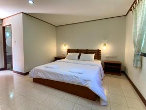 a bedroom with a large bed with white sheets at Mom and Me Resort & Farm in Doi Saket