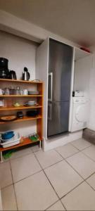 a kitchen with a stainless steel refrigerator and a tile floor at Accommodation for working team or big family in Odense