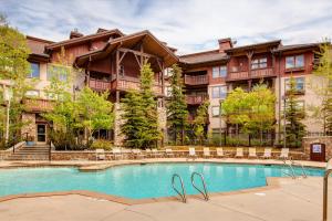 a swimming pool in front of a large building at Powderhorn Lodge 209 in Solitude