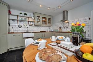 een keuken met een tafel met een brood erop bij Finest Retreats - Dunira in Falkland