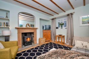 sala de estar con chimenea y sofá en Finest Retreats - Dunira, en Falkland