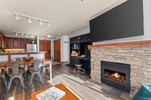 a kitchen and dining room with a stone fireplace at Powderhorn Lodge 209 in Solitude