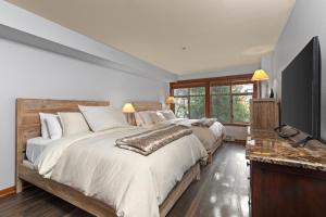 a bedroom with two beds and a flat screen tv at Powderhorn Lodge 209 in Solitude