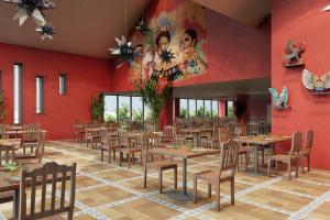 a restaurant with tables and chairs and a red wall at Les Rivages de Beauval in Saint-Aignan