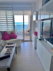 uma sala de estar com um sofá e uma televisão de ecrã plano em Relax em La Manga del Mar Menor