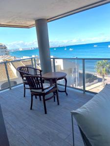 een balkon met een tafel en stoelen en de oceaan bij Relax in La Manga del Mar Menor