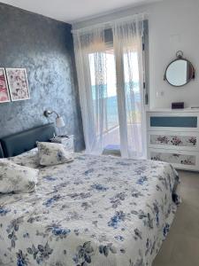 um quarto com uma cama com um cobertor azul e branco em Relax em La Manga del Mar Menor