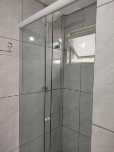 a shower with a glass door in a bathroom at Apartamento no coração de Porto Alegre in Porto Alegre +7 photos