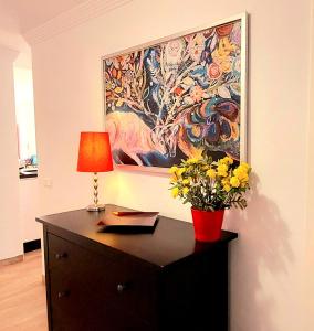 un escritorio con una lámpara y una pintura en la pared en Maravilloso apartamento en Nerja