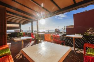 a patio with tables and chairs on a balcony at Chillax room see view in Imsouane