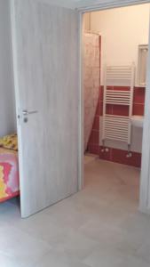 Ein Zimmer mit einer Tür zu einem Schlafzimmer mit einem Bett in der Unterkunft Valery AffittaCamere in Capannori