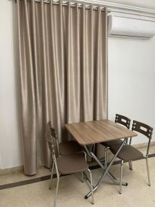 una mesa y sillas frente a una cortina en عمارة سيتي سنتر صفاقس en Sfax