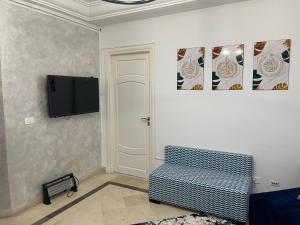 a living room with a couch and a flat screen tv at عمارة سيتي سنتر صفاقس in Sfax