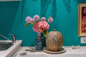 a vase filled with pink flowers sitting next to a sink at Casa Luminosa in Bocacangrejo