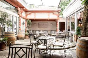 a patio with tables and chairs in a room with windows at Altstadthotel Messerschmitt in Bamberg