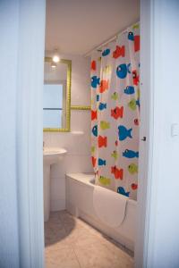a bathroom with a shower curtain with fishes on it at SEAFRONT UNBEATABLE LOCATION a in Benidorm +19 photos