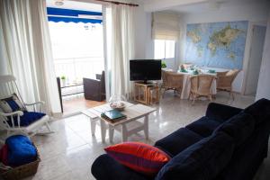 a living room with a blue couch and a table at SEAFRONT UNBEATABLE LOCATION a in Benidorm