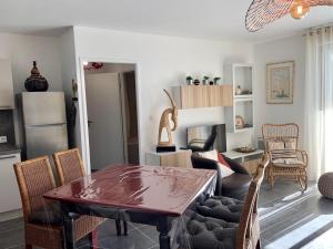eine Küche und ein Wohnzimmer mit einem Tisch und Stühlen in der Unterkunft Appartement Mèze, 3 pièces, 4 personnes - FR-1-604-22 in Mèze