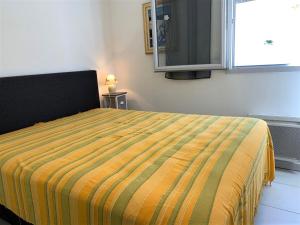 - une chambre dotée d'un lit avec une couverture jaune et verte dans l'établissement Appartement Mèze, 3 pièces, 4 personnes - FR-1-604-27, à Mèze