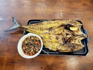 una bandeja con un pez muerto y un tazón de comida en UKCC (Ujung Karang Conference Center) en Sabang