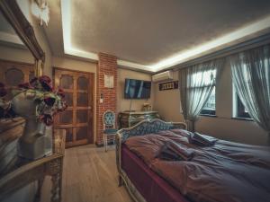 a bedroom with a bed and a tv and a window at Тhe Bohemian Lodge-entire house with sauna in Veliko Tŭrnovo