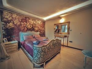 1 dormitorio con 1 cama grande y un mural en la pared en Тhe Bohemian Lodge-entire house with sauna, en Veliko Tŭrnovo