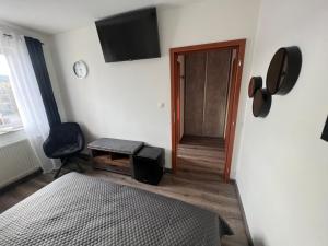 1 dormitorio con 1 cama y TV en la pared en Restaurace Pyramida en Karlovy Vary