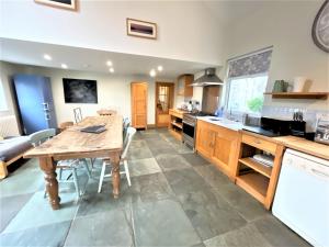 a kitchen with a wooden table and a dining room at Inglefall & Jasmine Cottages in Ingleton 