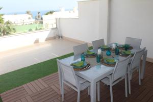 - Balcón con mesa blanca y sillas en Apartamento El Sueño Mojácar 1ª Línea de playa en Mojácar
