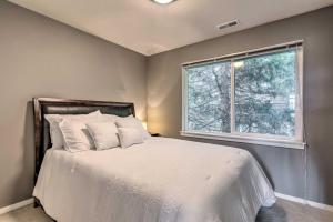 a bedroom with a white bed with a window at Quaint Issaquah Home - Walk to Shops and Dining in Issaquah