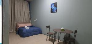 a bedroom with a bed and a table and chairs at Legon City Mall Short Stay Apartments for Business and Vacation - East Legon in Accra