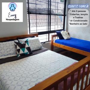 フロリアノポリスにあるEasy Quartos Floripaのベッド2台と窓のある寝室