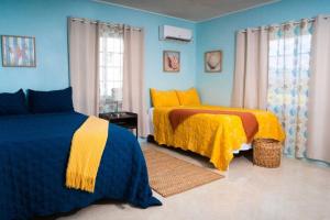 Treasured Gem Hideaway في تريجر آيلاند بيتش: غرفة نوم بسريرين باللونين الأصفر والأزرق