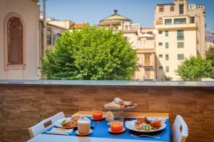 a table with two plates of food on a balcony at BB Hotel Pupi 93 in Palermo