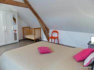 una camera da letto con un letto con cuscini rosa di Gîte Agonges, 3 pièces, 4 personnes - FR-1-489-36 ad Agonges